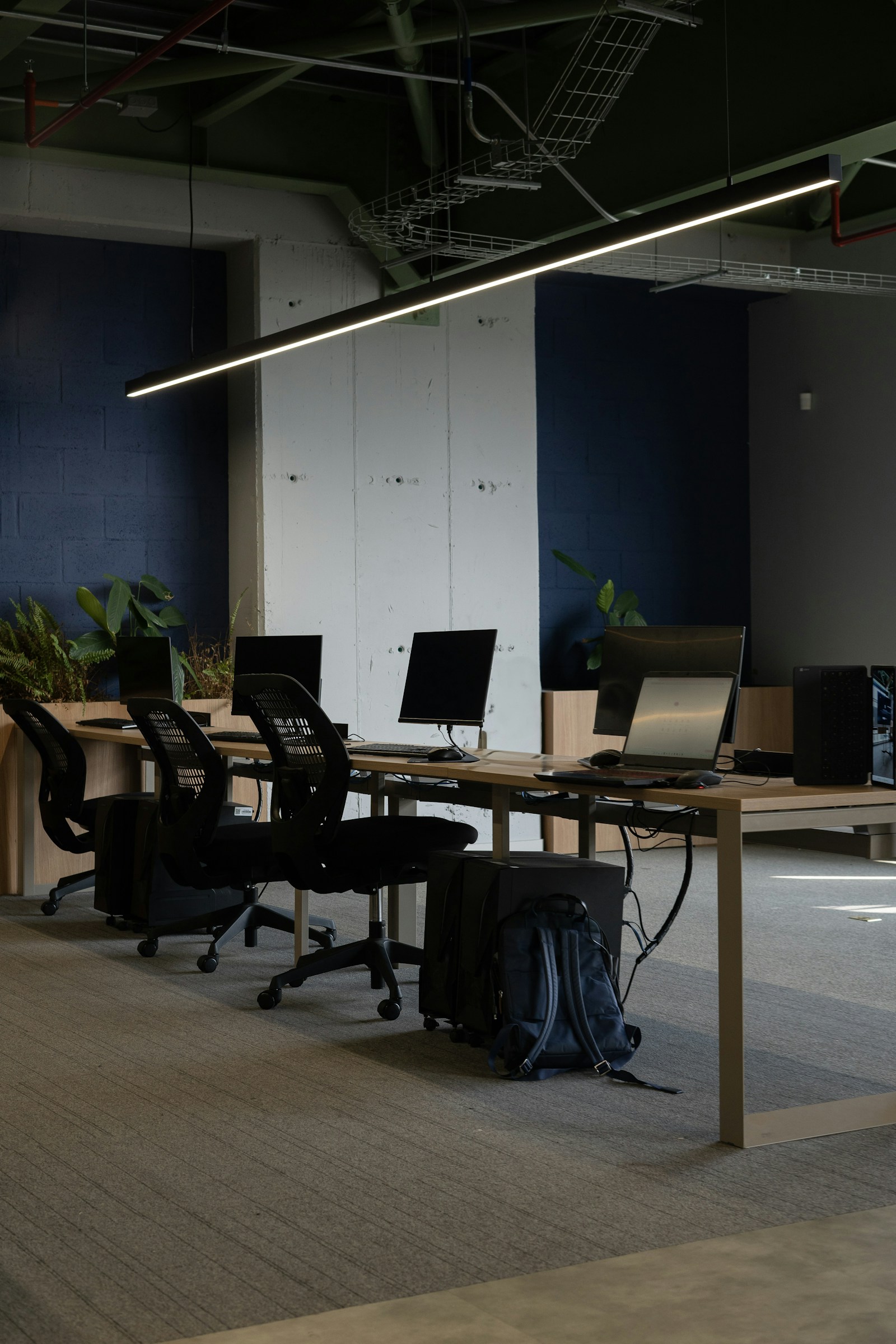 Puestos de trabajo con sillas y pantallas en un espacio compartido vacío